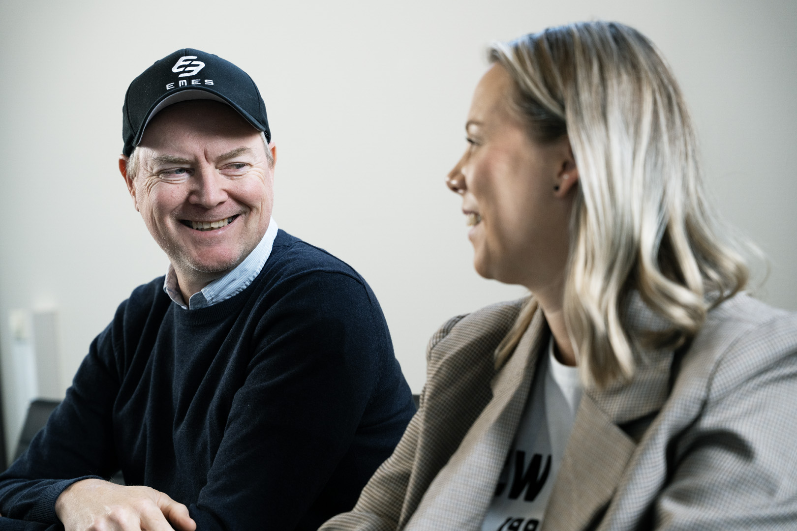 To personer smiler og prater sammen under et møte om ladeløsninger for tungtransport hos EMES.